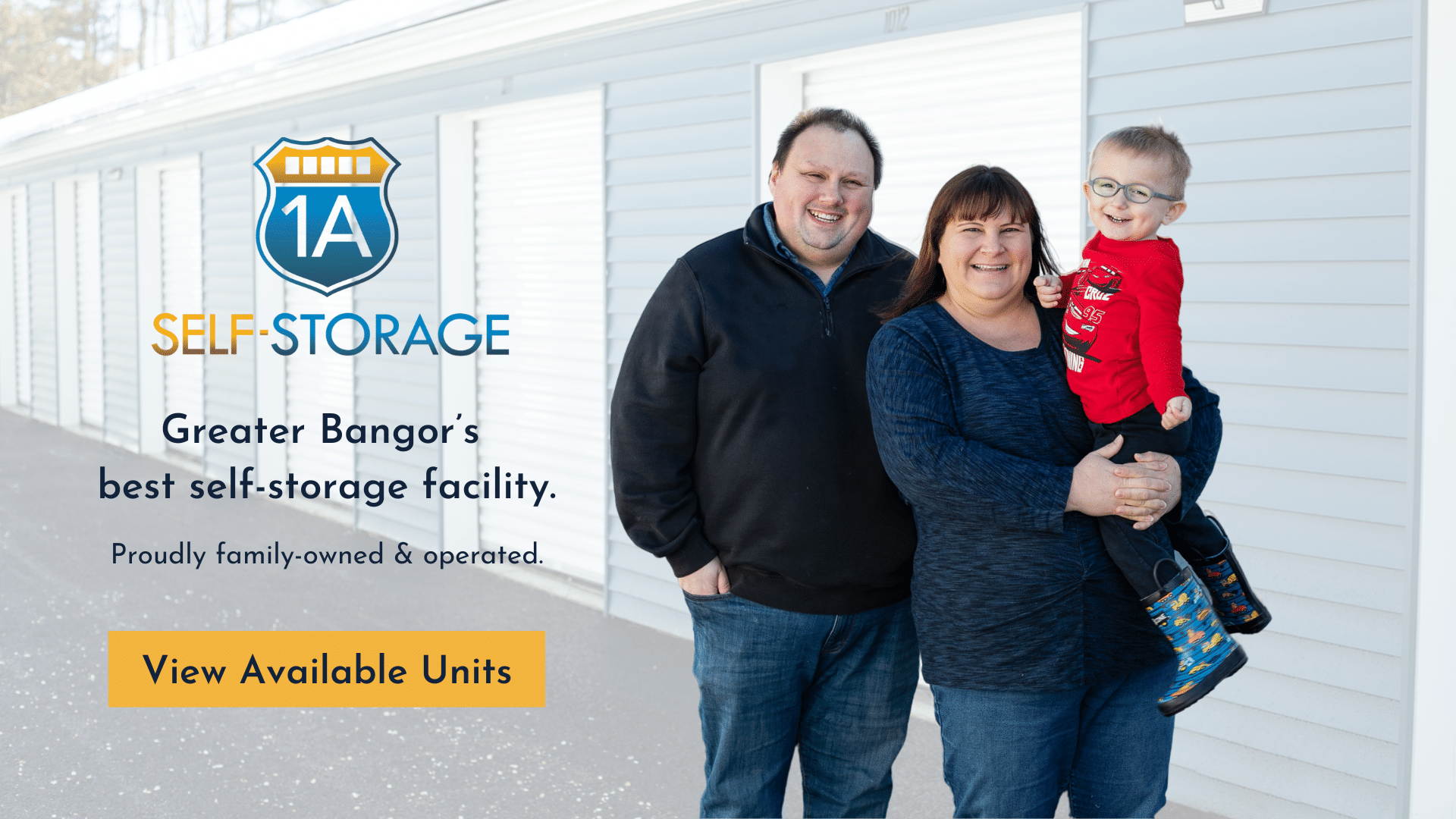 Justin, Nicki, and their son stand in front of the storage units at 1A Self-Storage.